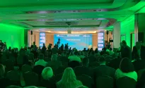 Sala konferencyjna pełna ludzi oraz scena